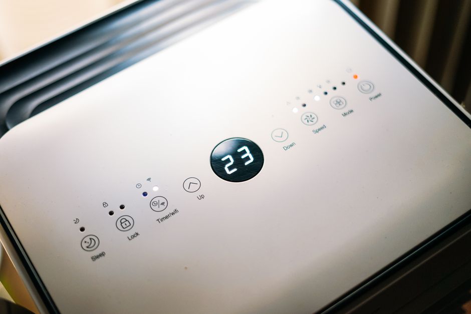 Verplaatsbare luchtontvochtiger in een moderne woonkamer, verbetert luchtkwaliteit en vermindert vochtproblemen.